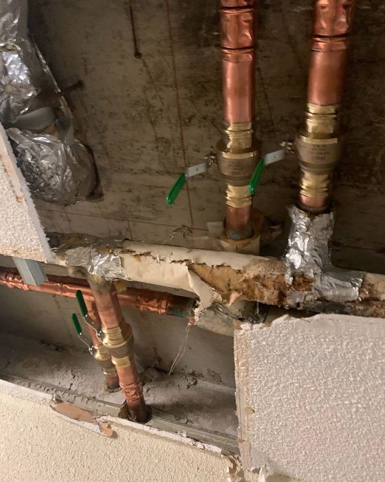 New copper risers with ball valves with green handles in a ceiling access opening