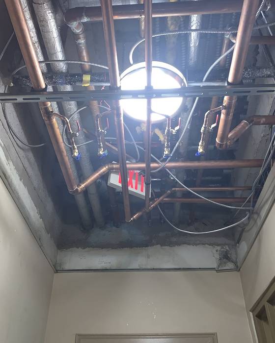 Hallway ceiling opened up showing new copper piping