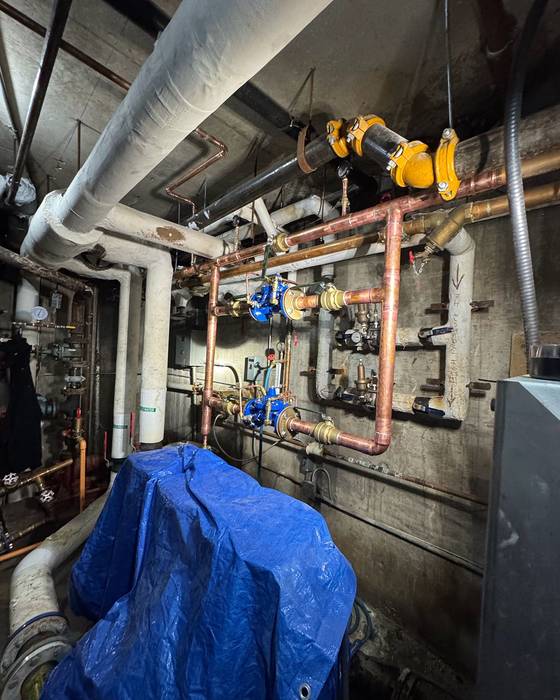 Pressure-reducing valve station with blue valves and copper piping