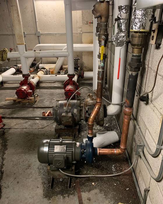 Pump room with two base-mounted pumps, new copper piping and a valve