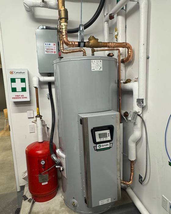 Electric A. O. Smith water heater with a red expansion tank, mixing valve and copper piping